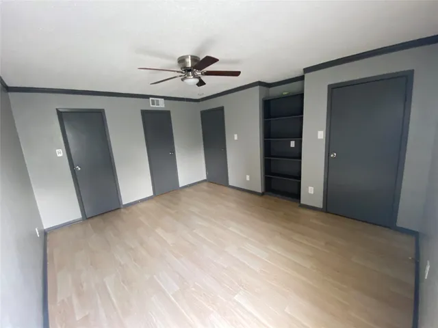 a view of a big room with closet and chandelier fan