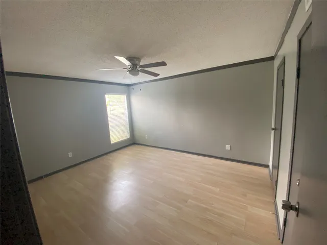 an empty room with windows and fan
