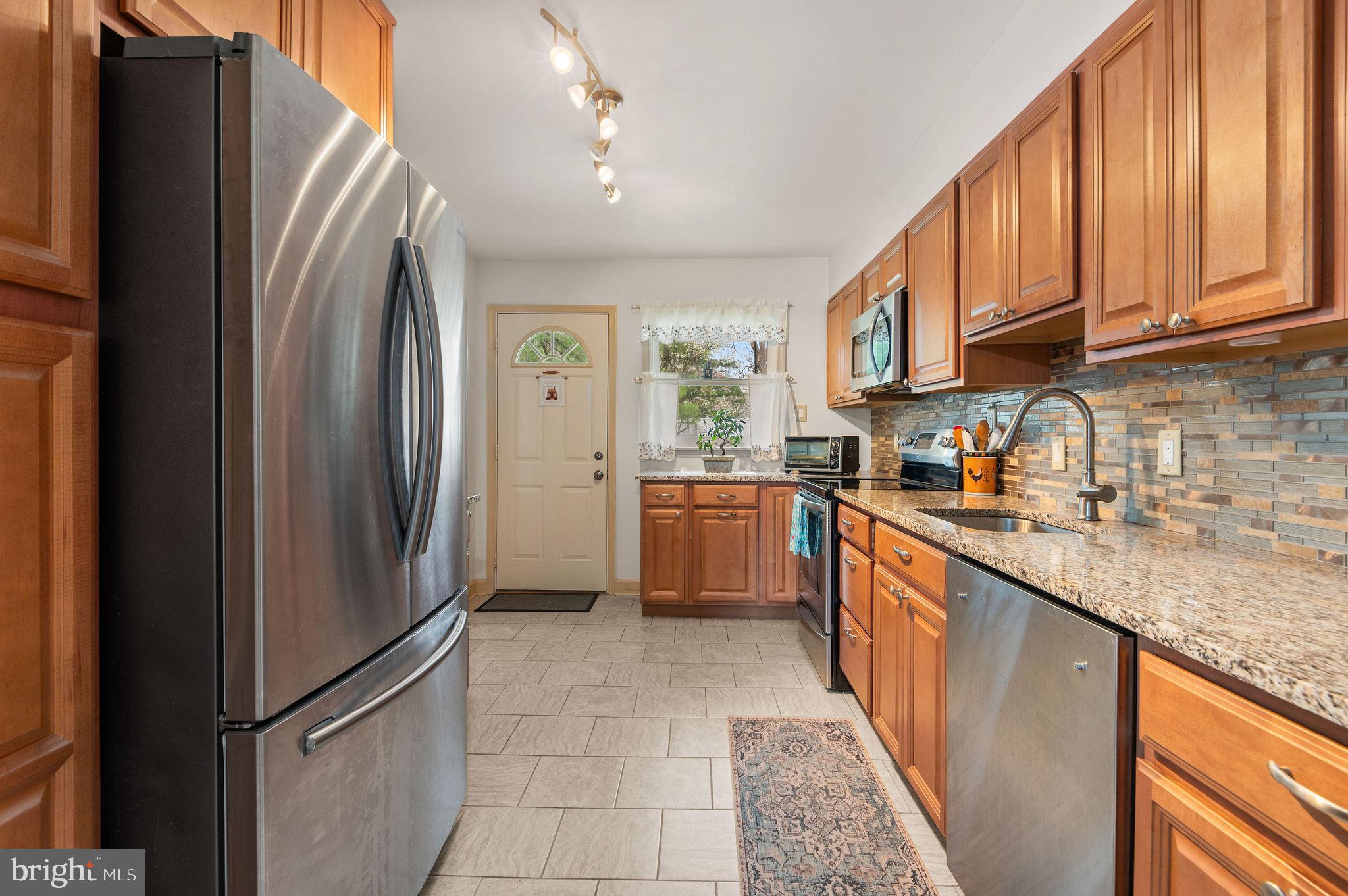 1027 Rozel Avenue Southampton, PA 18966 - Photo 3 of 24 a kitchen with stainless steel appliances granite countertop a refrigerator sink and cabinets