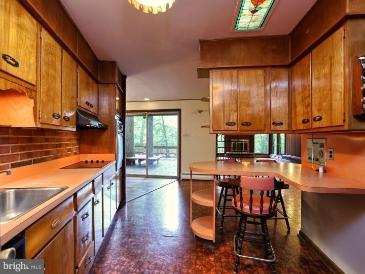 41 Robin Road Moorestown, NJ 08057 - Photo 11 of 23 a open kitchen with stainless steel appliances granite countertop a stove top oven a dining table and chairs with wooden floor