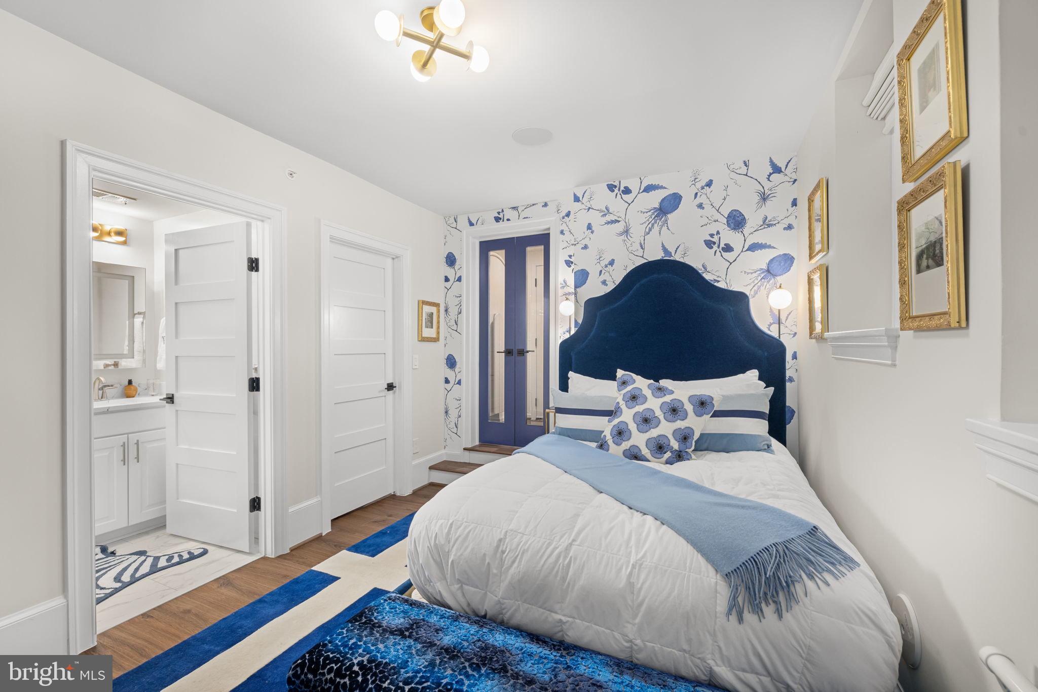 1305 30th Street Northwest, Unit 106 Washington, DC 20007 - Photo 10 of 14 a bedroom with a bed and a chandelier