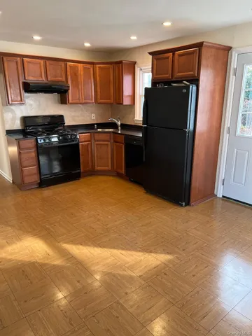 a kitchen with stainless steel appliances granite countertop a refrigerator a stove a sink and a microwave