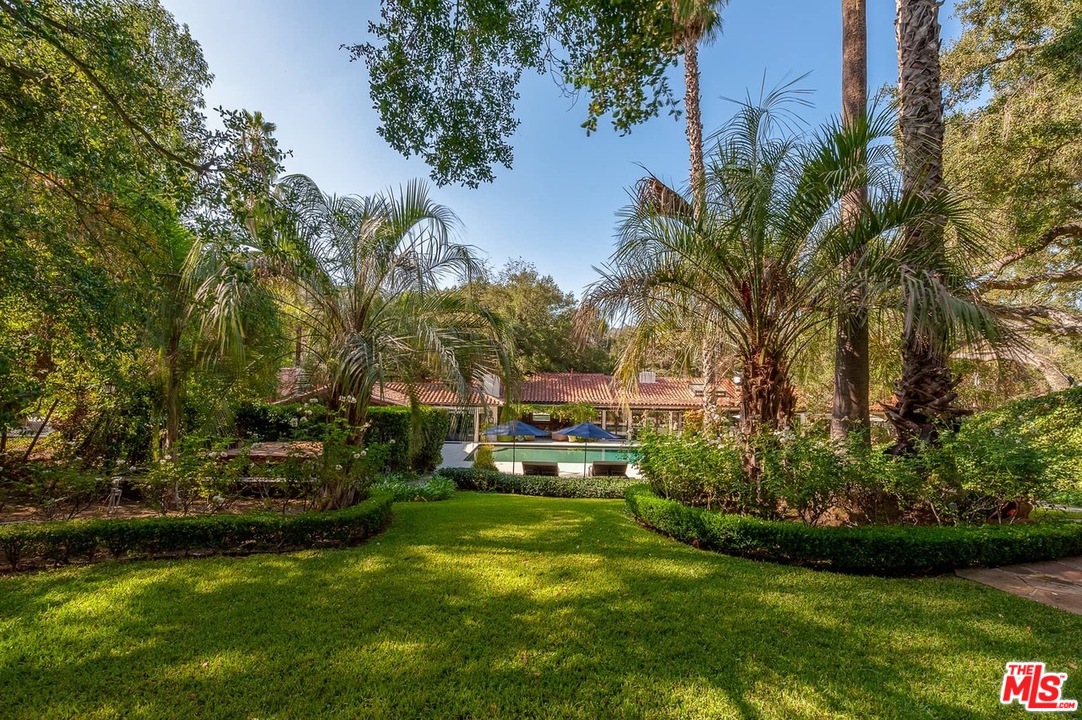 a view of a house with a big yard and potted plants