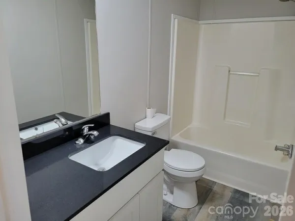 a kitchen with granite countertop a sink a stove and refrigerator