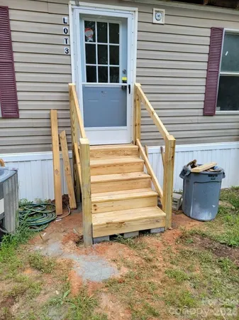a view of a house with a yard and stairs