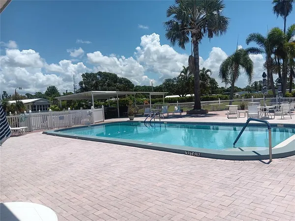 a view of a house with swimming pool and sitting area