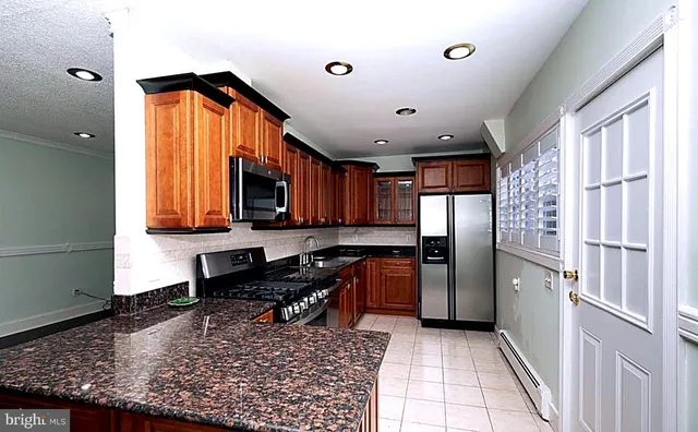a kitchen with refrigerator and cabinets