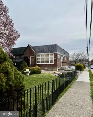 a front view of house with yard and car parked