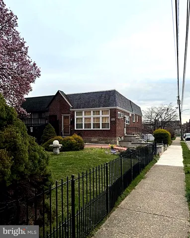 a front view of house with yard and car parked