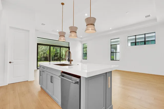 a kitchen with a sink a center island and a wooden floor