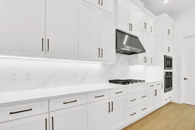 a kitchen with white cabinets and appliances