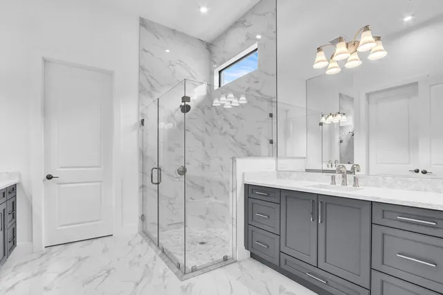a bathroom with a double vanity sink mirror and shower