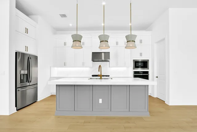 a view of kitchen with stainless steel appliances granite countertop refrigerator sink and cabinets