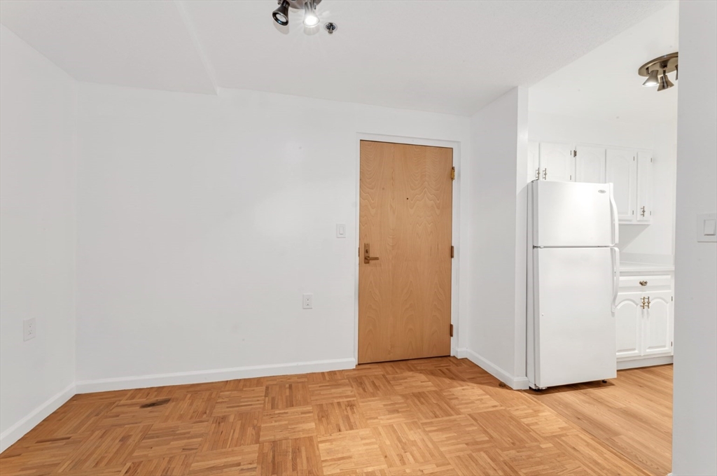 357 Commercial Street, Unit 219 Boston, MA 02109 - Photo 4 of 16 a view of a kitchen with refrigerator and wooden floor