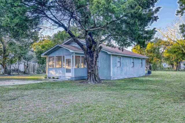 a view of a house with garden and trees