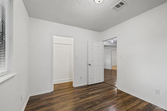 a view of empty room with wooden floor and sink