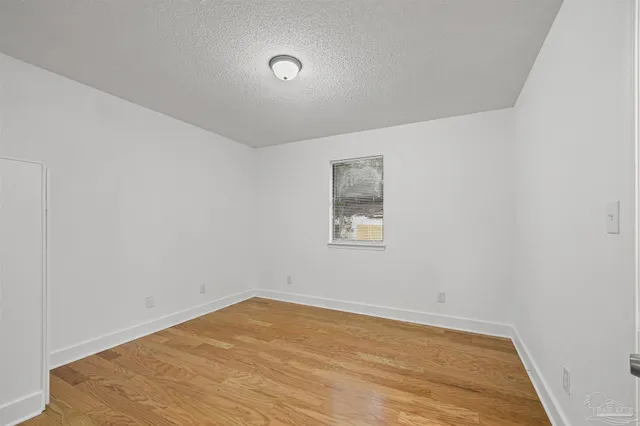 a view of a big room with wooden floor and windows in a room