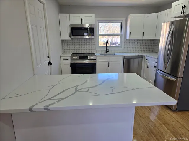 a view of a kitchen with a sink and a refrigerator