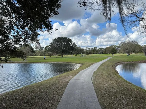 a view of a lake with a yard and large trees