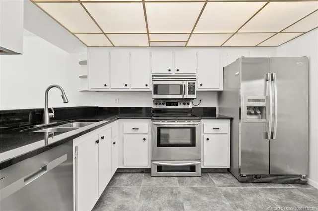 a kitchen with stainless steel appliances a refrigerator sink and cabinets