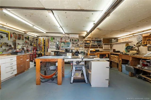 a open kitchen with stainless steel appliances kitchen island granite countertop a table chairs and a refrigerator