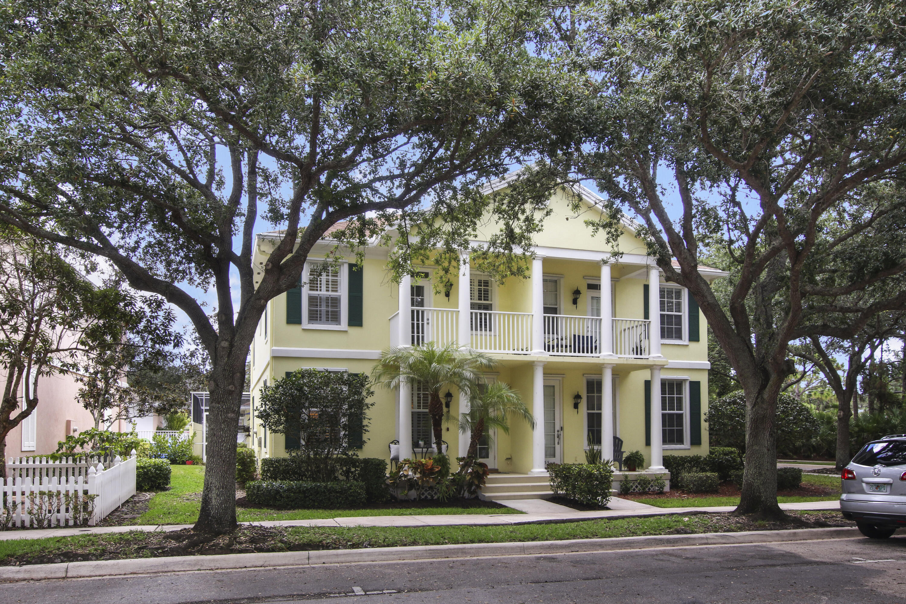 a front view of residential houses with yard and trees