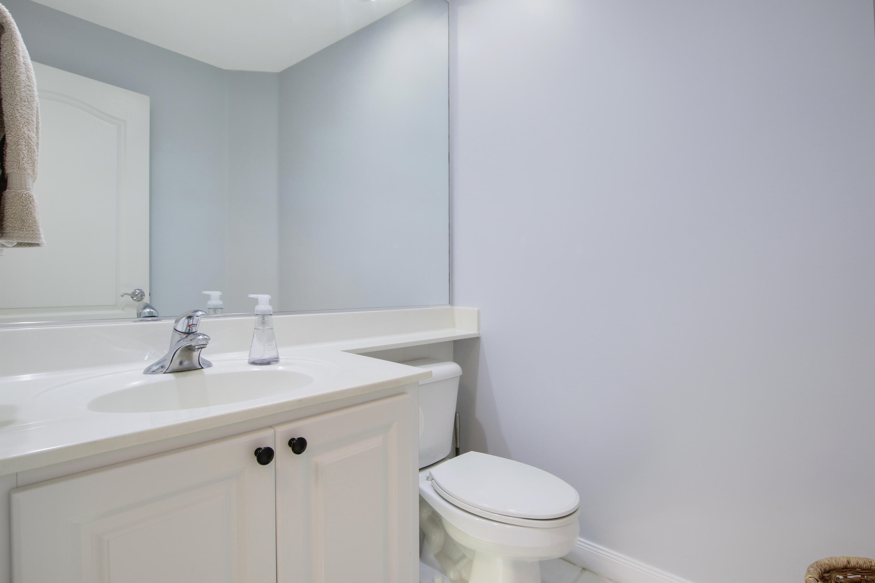 153 Andover Drive Jupiter, FL 33458 - Photo 21 of 25 a bathroom with a sink a toilet and a mirror