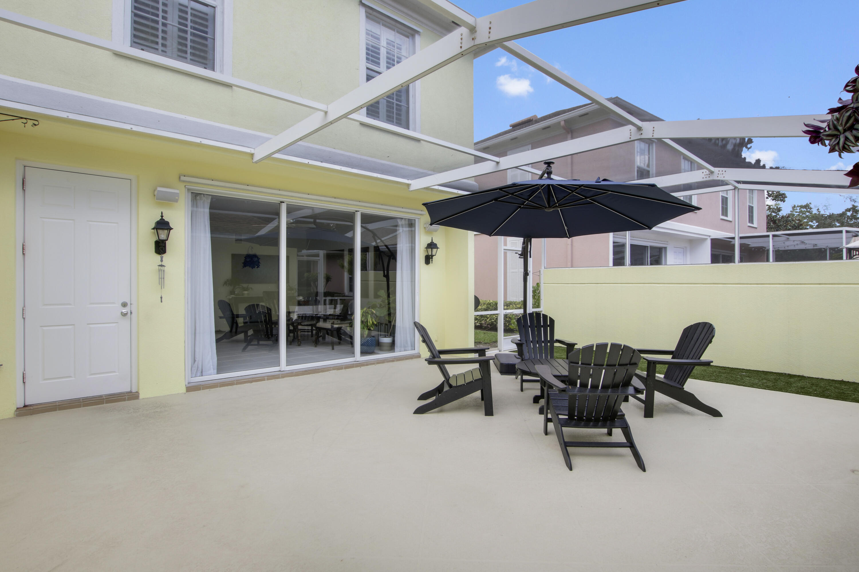 153 Andover Drive Jupiter, FL 33458 - Photo 24 of 25 a view of a patio with table and chairs under an umbrella