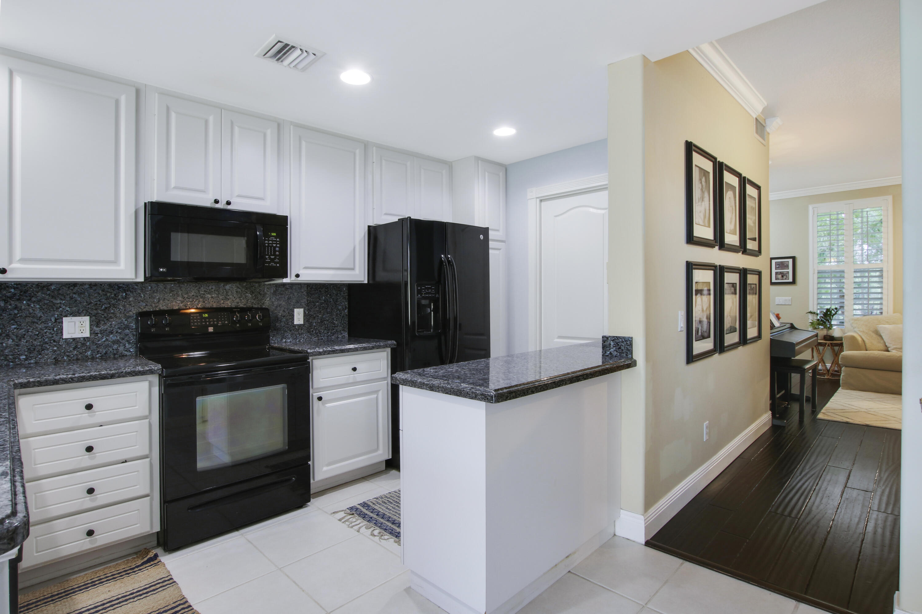 153 Andover Drive Jupiter, FL 33458 - Photo 8 of 25 a kitchen with stainless steel appliances a stove microwave and a refrigerator