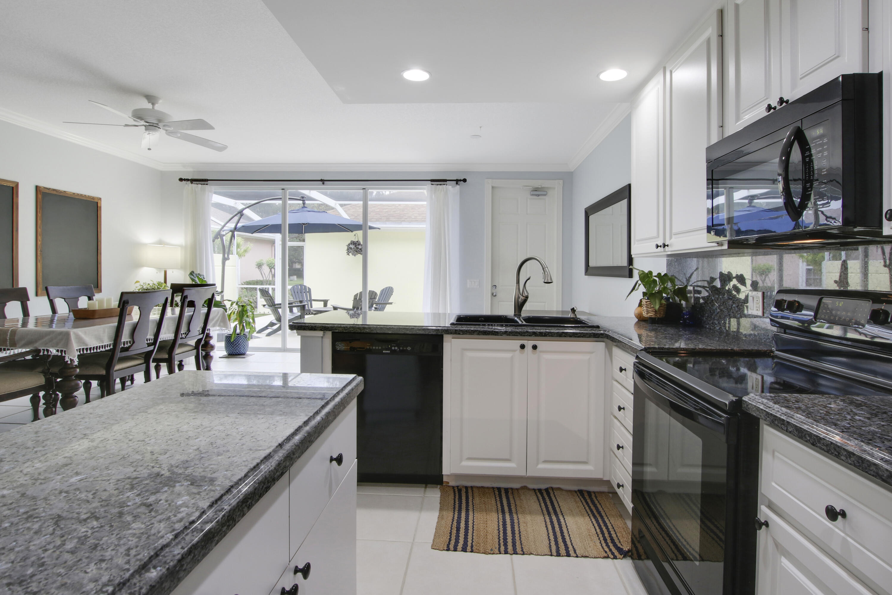 153 Andover Drive Jupiter, FL 33458 - Photo 10 of 25 a kitchen with stainless steel appliances granite countertop a sink stove and cabinets