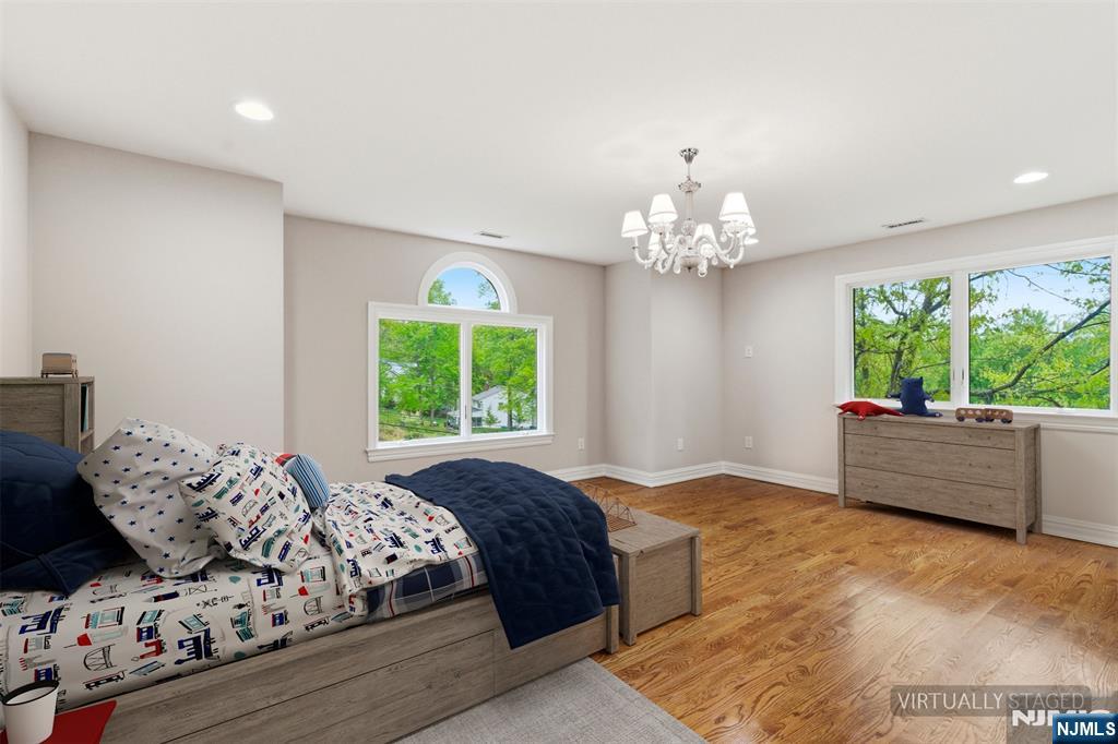 767 Orangeburgh Road River Vale, NJ 07675 - Photo 23 of 49 a spacious bedroom with a large bed and a chandelier