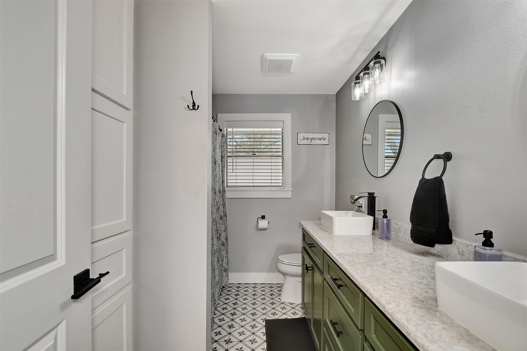205 Munz Street Brenham, TX 77833 - Photo 24 of 48 a bathroom with a double vanity sink and mirror with shower