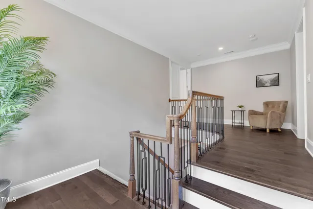 a view of an empty room with wooden floor and a fireplace