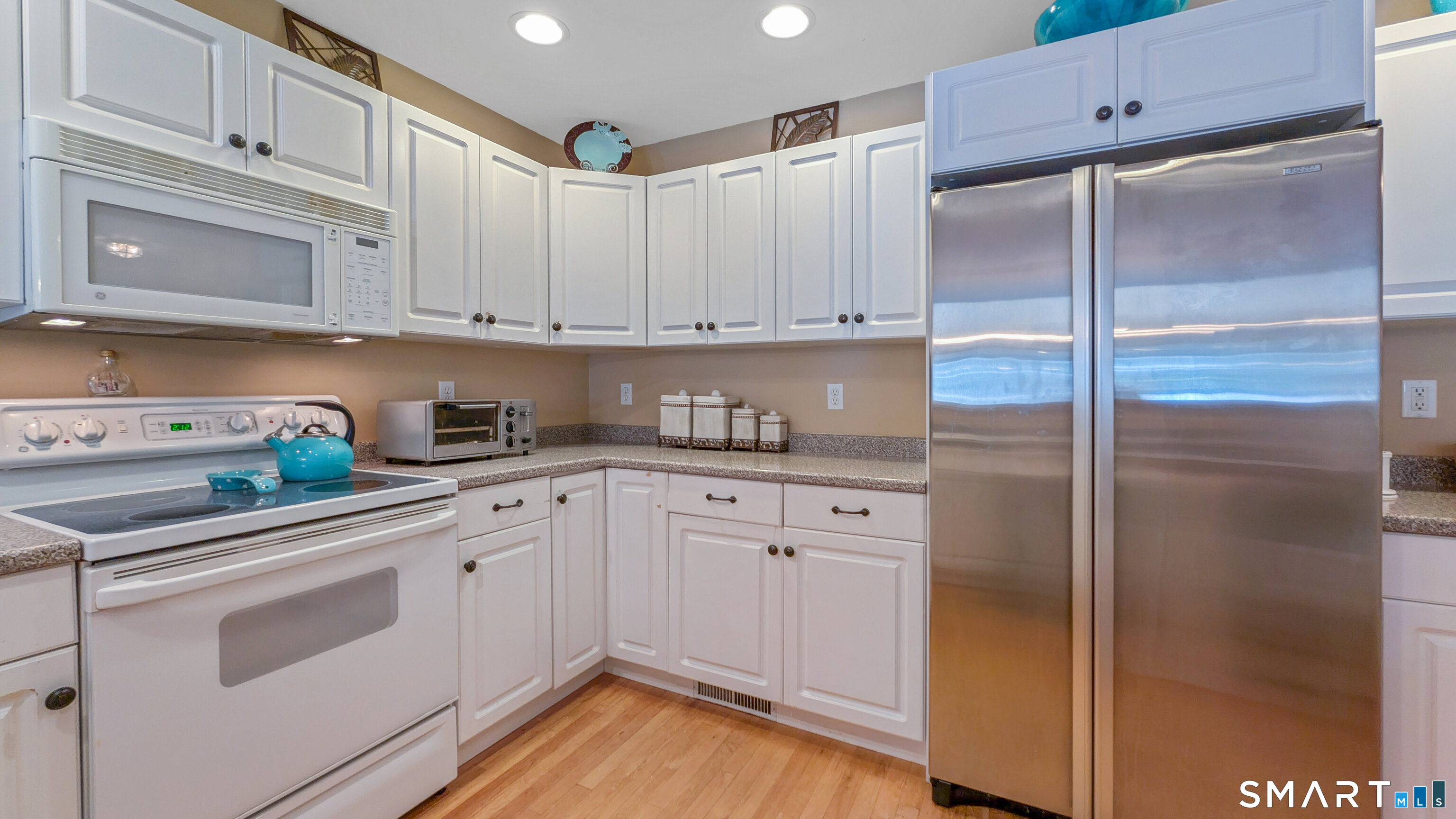 123 Louis Hill Road, Unit 123 Newtown, CT 06482 - Photo 8 of 35 a kitchen with stainless steel appliances granite countertop a refrigerator and white cabinets