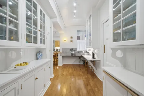 a large kitchen with a lot of counter space and wooden floor