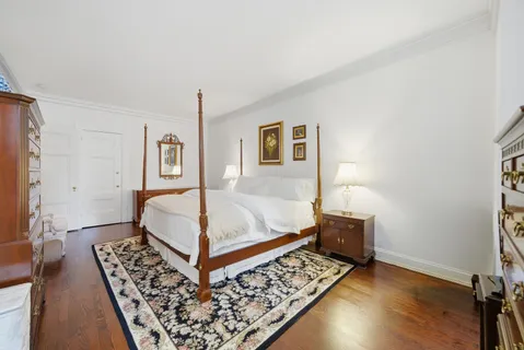 a bedroom with a bed rug and wooden floor