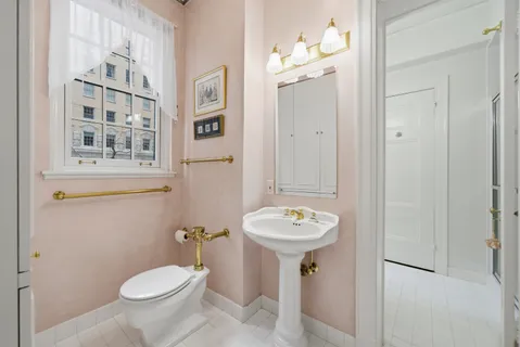 a bathroom with a toilet sink and mirror