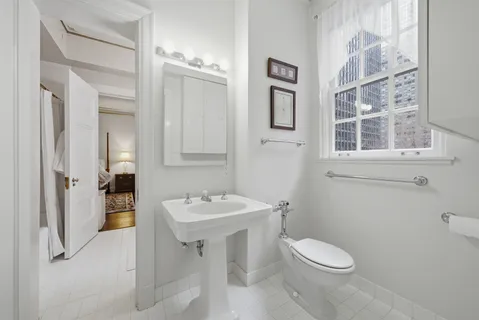 a bathroom with a toilet sink and mirror