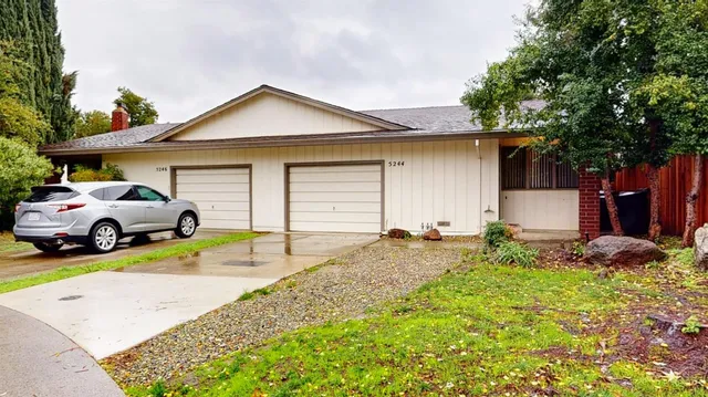 a view of a house with backyard and sitting area