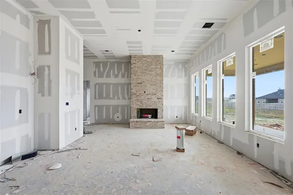 a view of an empty room with a fireplace and a window