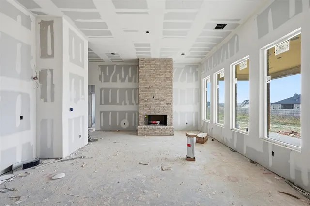 a view of an empty room with a fireplace and a window