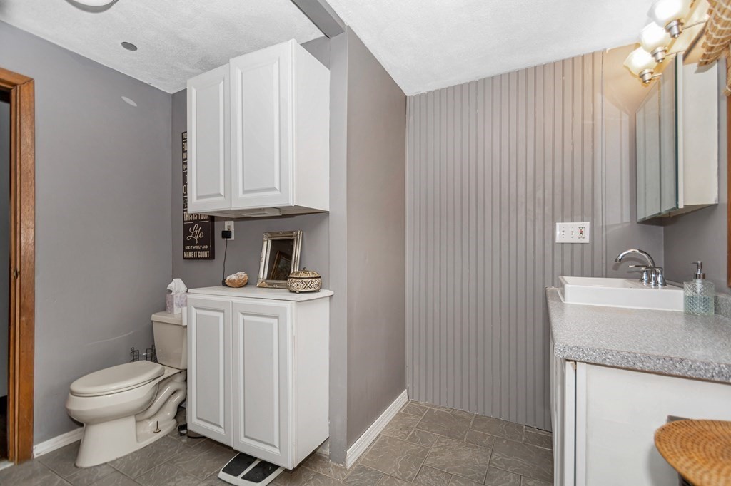 13 Ranch Road Chelmsford, MA 01824 - Photo 31 of 42 a bathroom with a granite countertop sink a toilet and a vanity