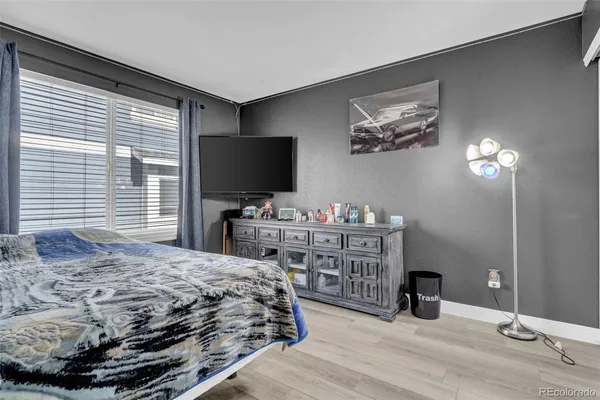a bedroom with a bed and a flat tv screen on dresser