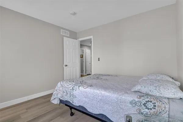 a bedroom with a bed and wooden floor