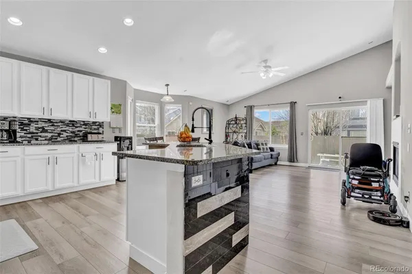 a kitchen with stainless steel appliances granite countertop a stove and a wooden floors