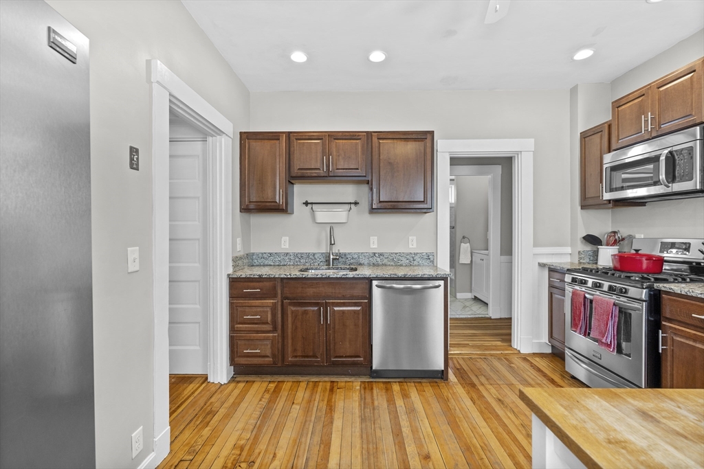 30 Chester Avenue, Unit 1 Waltham, MA 02453 - Photo 5 of 14 a kitchen with stainless steel appliances granite countertop a sink and stove top oven