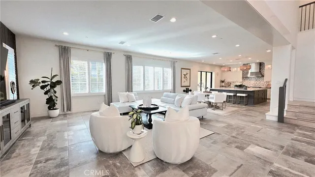 a large white kitchen with a large window a stove a dining table and chairs