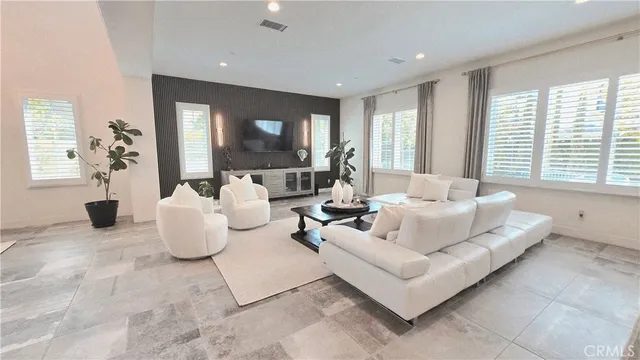 a large white kitchen with a large window and stainless steel appliances