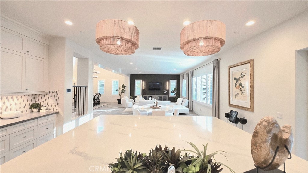 56 Redshift Irvine, CA 92618 - Photo 23 of 67 a large white kitchen with a large window a stove a dining table and chairs