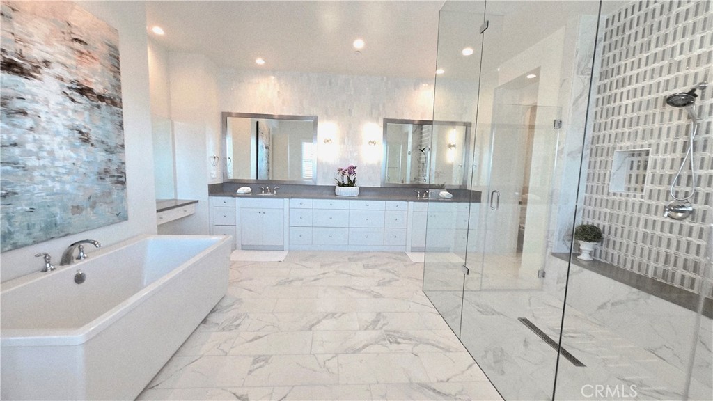 56 Redshift Irvine, CA 92618 - Photo 34 of 67 a large white bathroom with a large tub a sink a vanity and a shower